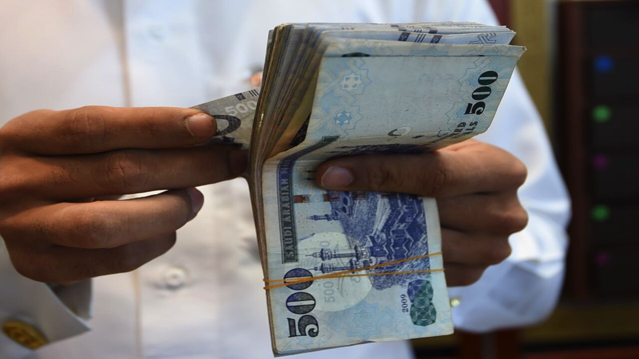 A Saudi man counts banknotes at his jewelry shop at Tiba market in Riyadh, on Oct. 3, 2016.