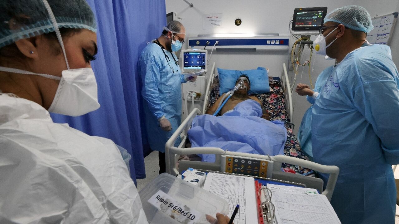 Iraqi medical workers check on a patient at the coronavirus ward of Al-Shifaa Hospital in the capital Baghdad