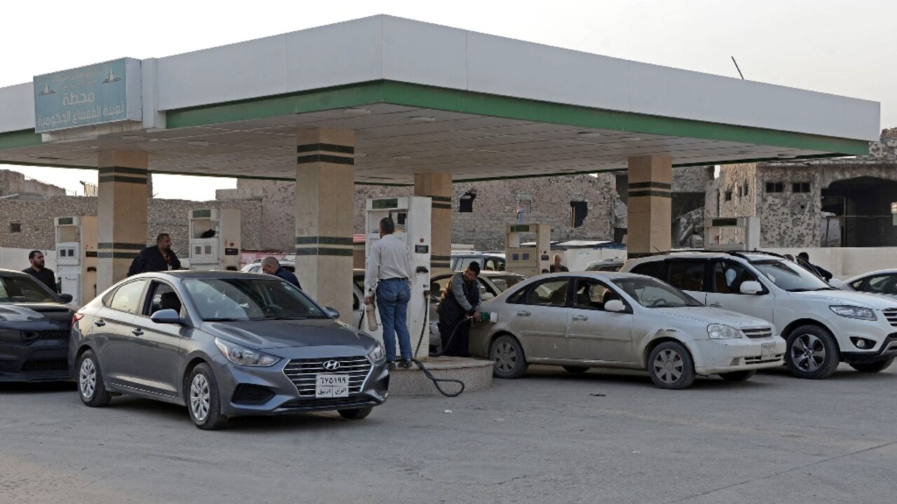 Iraqis wait in a queue at a petrol station in the northern city of Mosul to fill up their cars amid shortages authorities say are due to smuggling to neighbouring Kurdistan