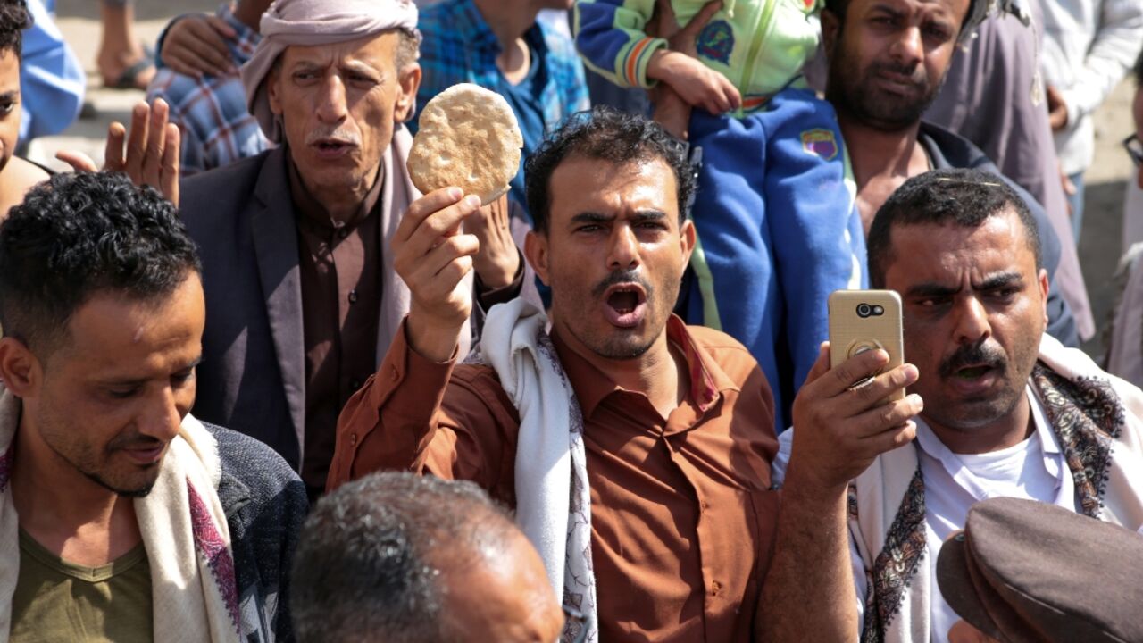 A Yemeni man holds up a piece of bread during a protest against the deteriorating economic conditions