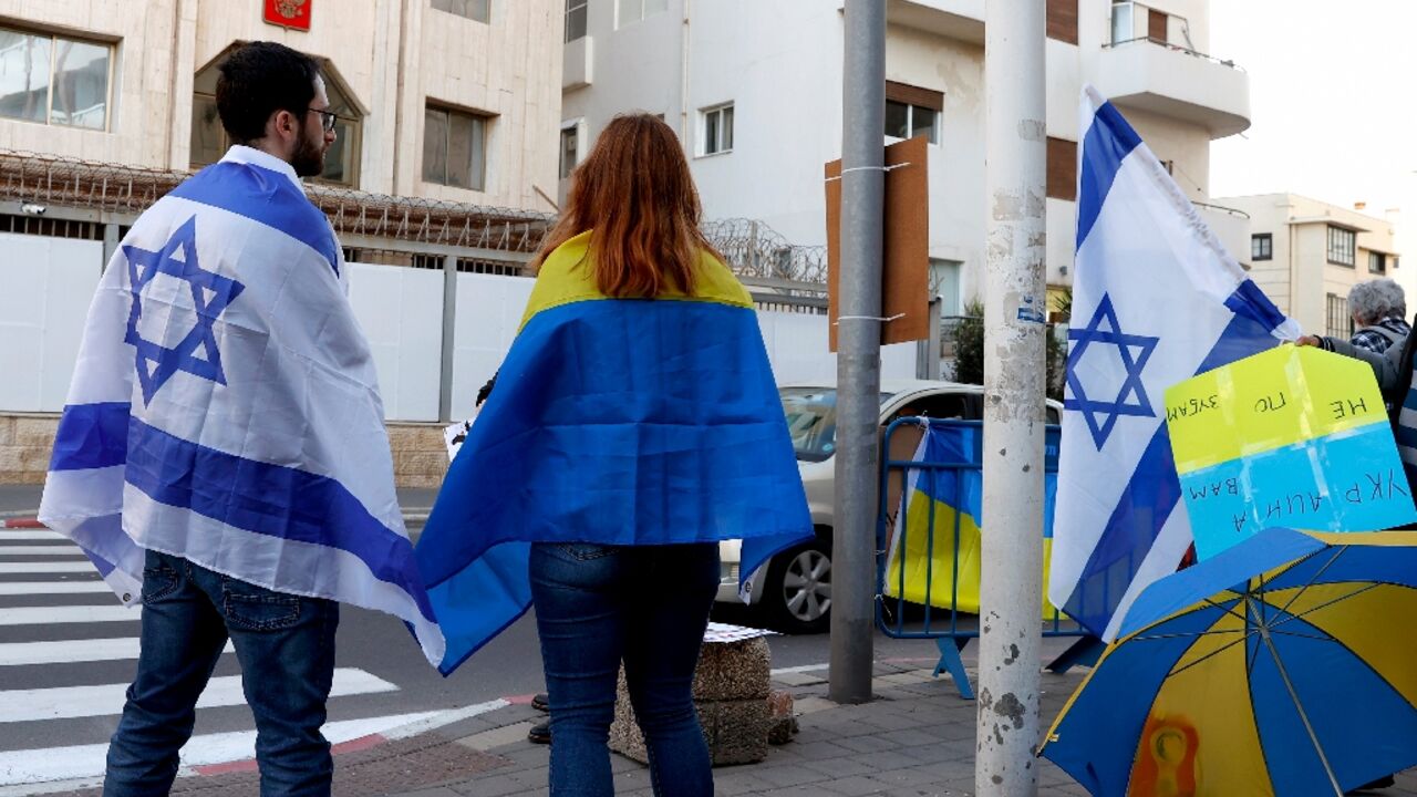 People clad in the Israeli and Ukranian flags take part in a Tel Aviv protest against Russia's attack on Ukraine