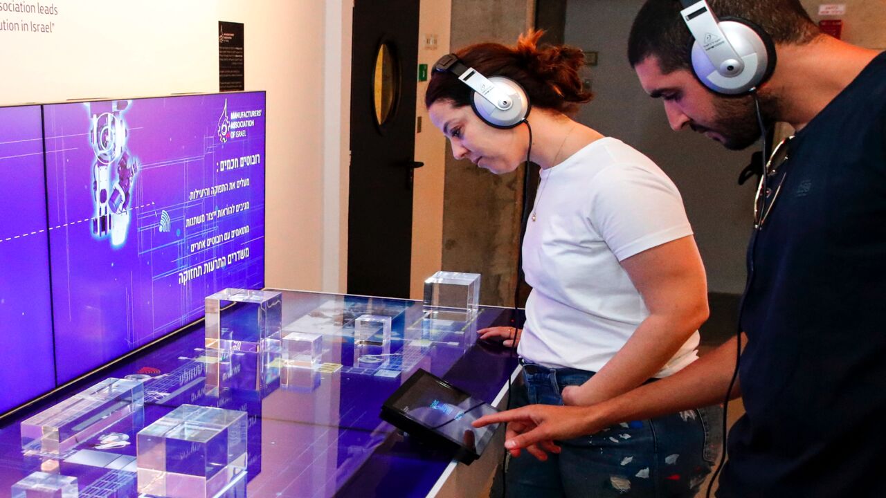 Visitors at a display by Israel’s Manufacturers Association at Israeli Expo technology exhibit in Tel Aviv. Sept. 3, 2019.