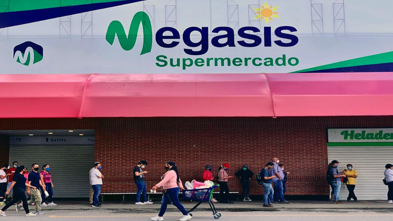 People queue outside Megasis, the first Iranian supermarket in Venezuela, in Caracas on July 31, 2020.