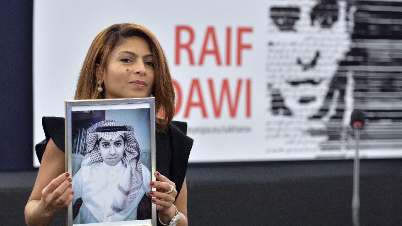 Ensaf Haidar holds a picture of her husband, Saudi blogger Raif Badawi, after accepting the European Parliament's Sakharov human rights prize on his behalf
