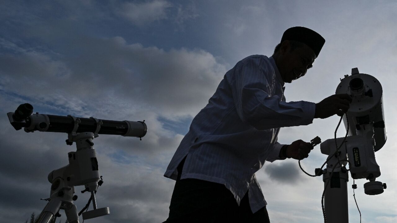 An observatory officer prepares a telescope before looking for the moon to mark the start of Islam's holy month of Ramadan at Lhoknga beach in the Indonesian province of Aceh
