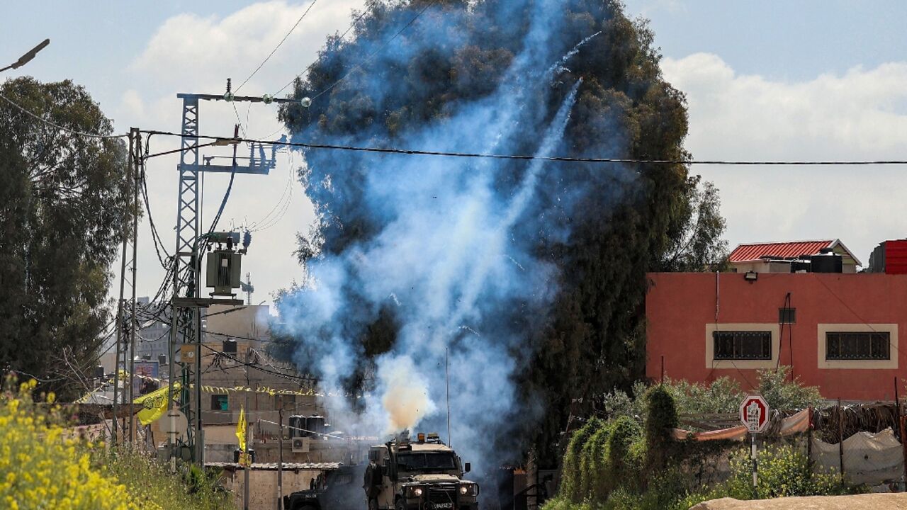 Tear gas canisters are fired from an Israeli military vehicle near the Palestinian refugee camp of Jenin in the occupied West Bank on April 9, 2022