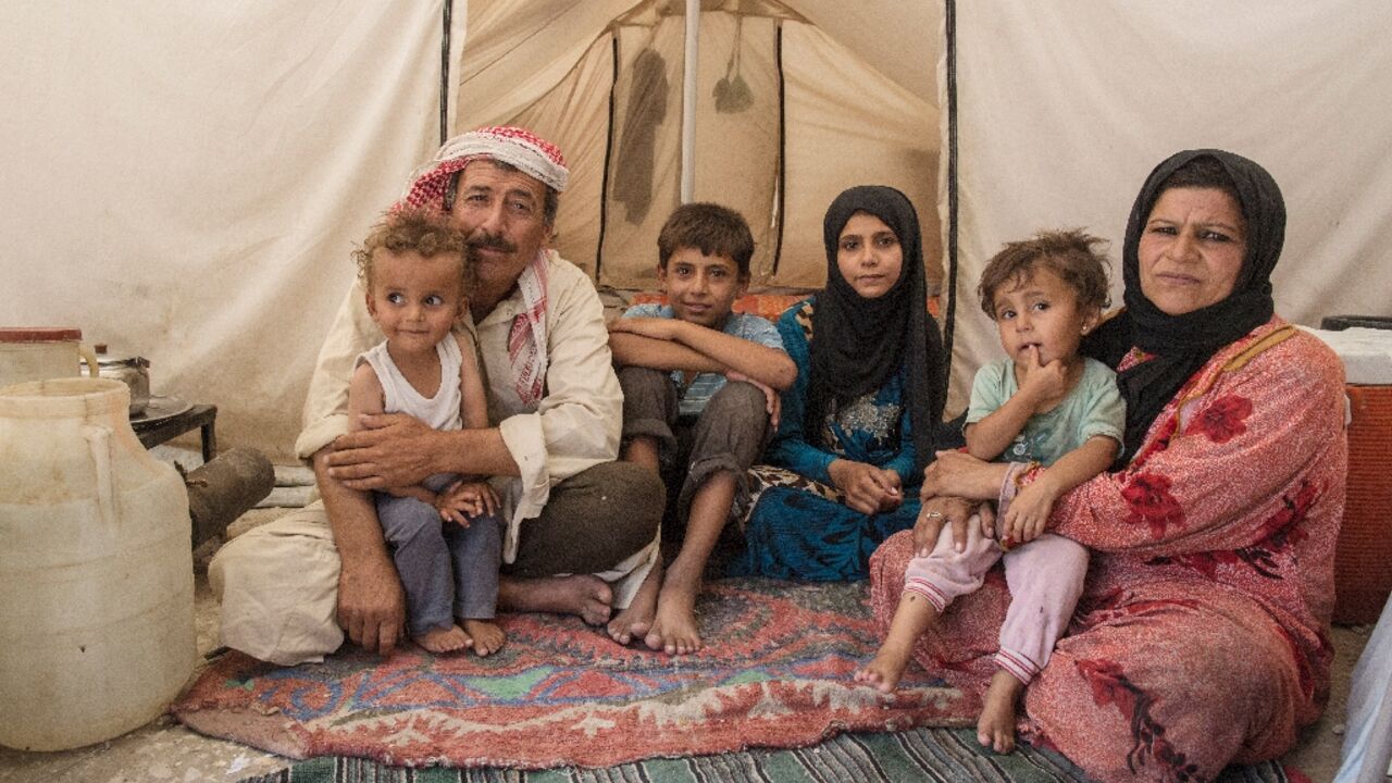A Syrian family from Raqqa inside a tent in a camp for people displaced by the war against the Islamic State (IS) group, in Ain Issa, after the US battle to liberate Raqqa, which saw massive damage to civilians