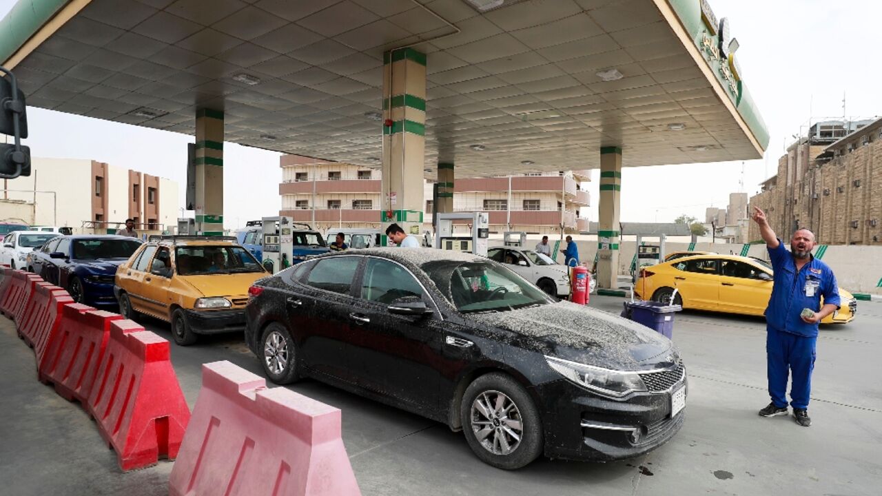 Iraqis crowd a Baghdad petrol station to fill up after some filling stations shut off their pumps to protest government policies on fuel