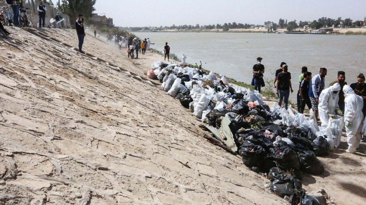 Young Iraqi volunteers take part in a cleanup campaign on the banks of the Tigris River, a rare environmental project in the war-battered country 