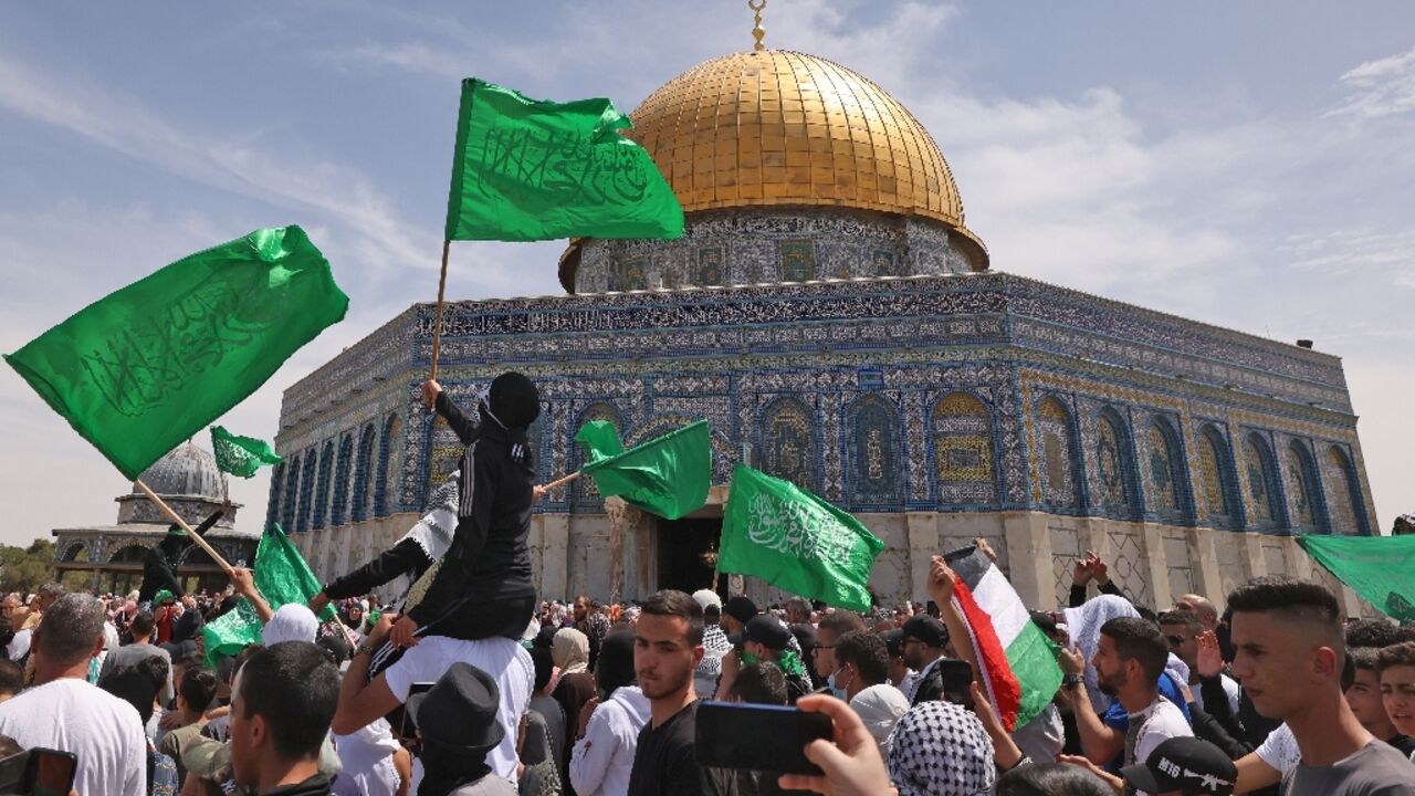 Palestinians wave national and Islamic flags inside Jerusalem's Al-Aqsa Mosque complex following prayers of the third Friday of the Muslim holy month of Ramadan