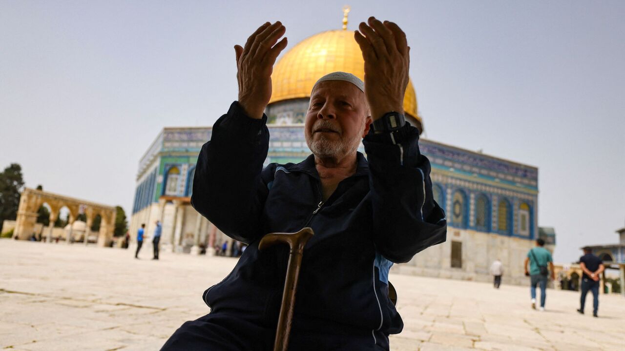 A Palestinian man prays in front of the Dome of Rock mosque at the Al-Aqsa mosque compound in Jerusalem's Old City on April 17, 2022. 
