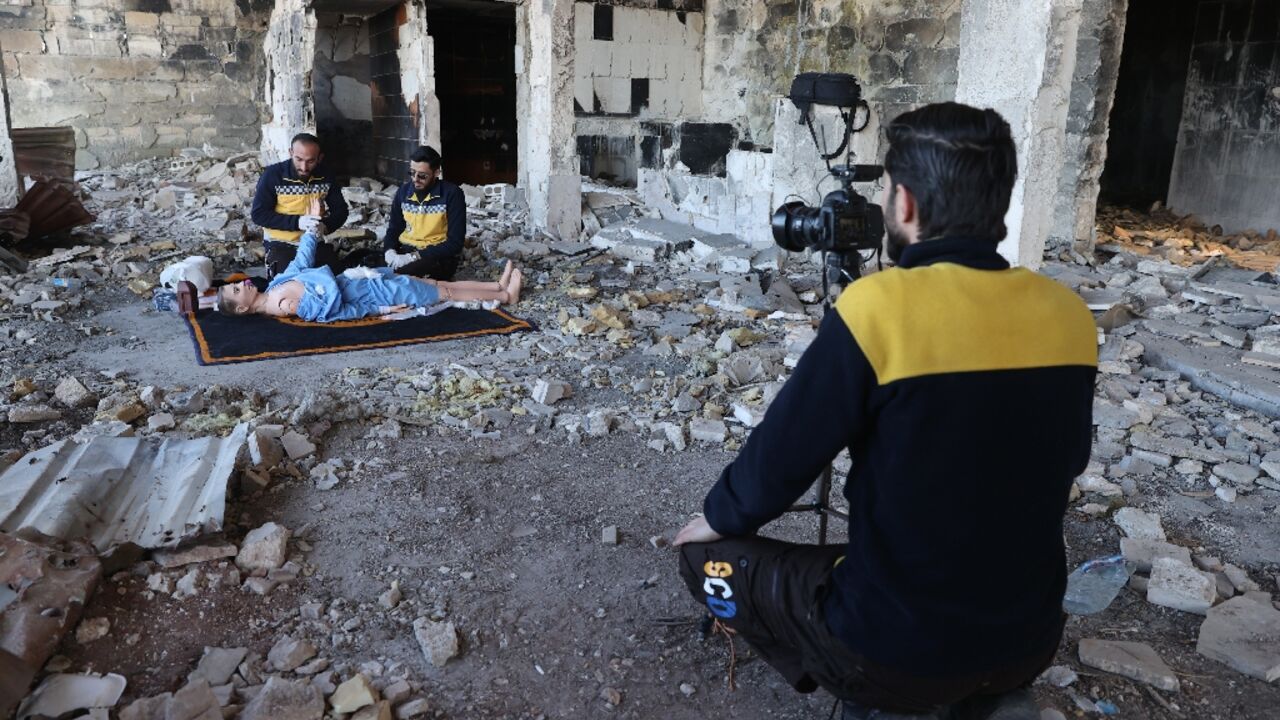 Members of the Syrian civil defence known as the White Helmets use a dummy to demonstrate their rescue skills during a video shoot for an instructive film intended for Ukrainian rescuers, in the war-ravaged Syrian town of Ariha