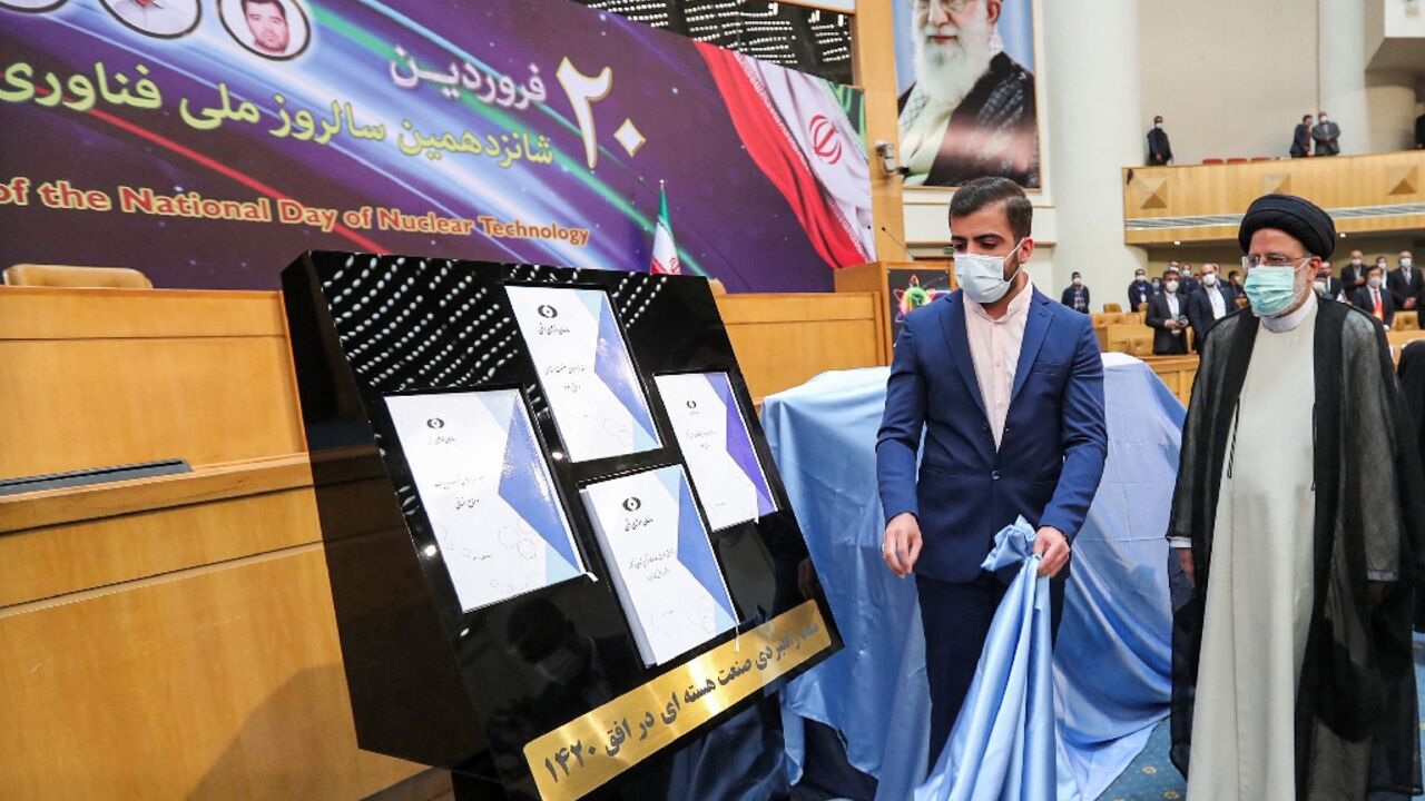 Iran's President Ebrahim Raisi (R) witnesses unveiling of the "Nuclear Industry Strategic Document" for the next two decades at an event during the 16th "National Day of Nuclear Technology" in Tehran on April 9, 2022