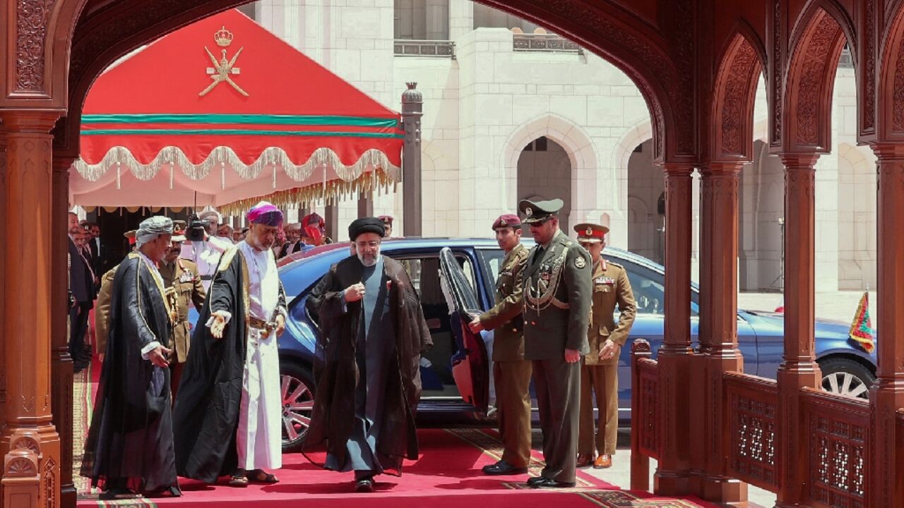 Sultan of Oman Haitham bin Tariq Al Said (2nd L) welcomes Iran's President Ebrahim Raisi (C) at the airport in the Omani capital Muscat