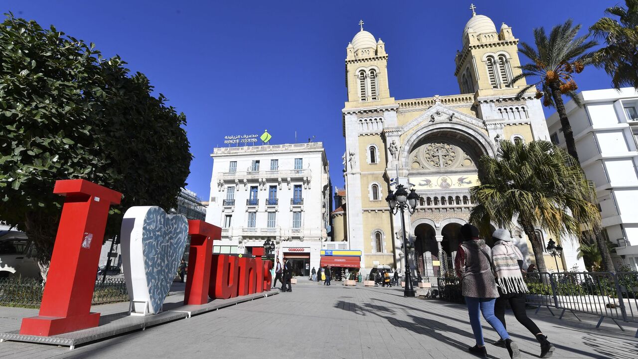 People walk past Saint-Vincent de Paul Cathedral on Habib Bourguiba Avenue in Tunis on Dec. 14, 2021.