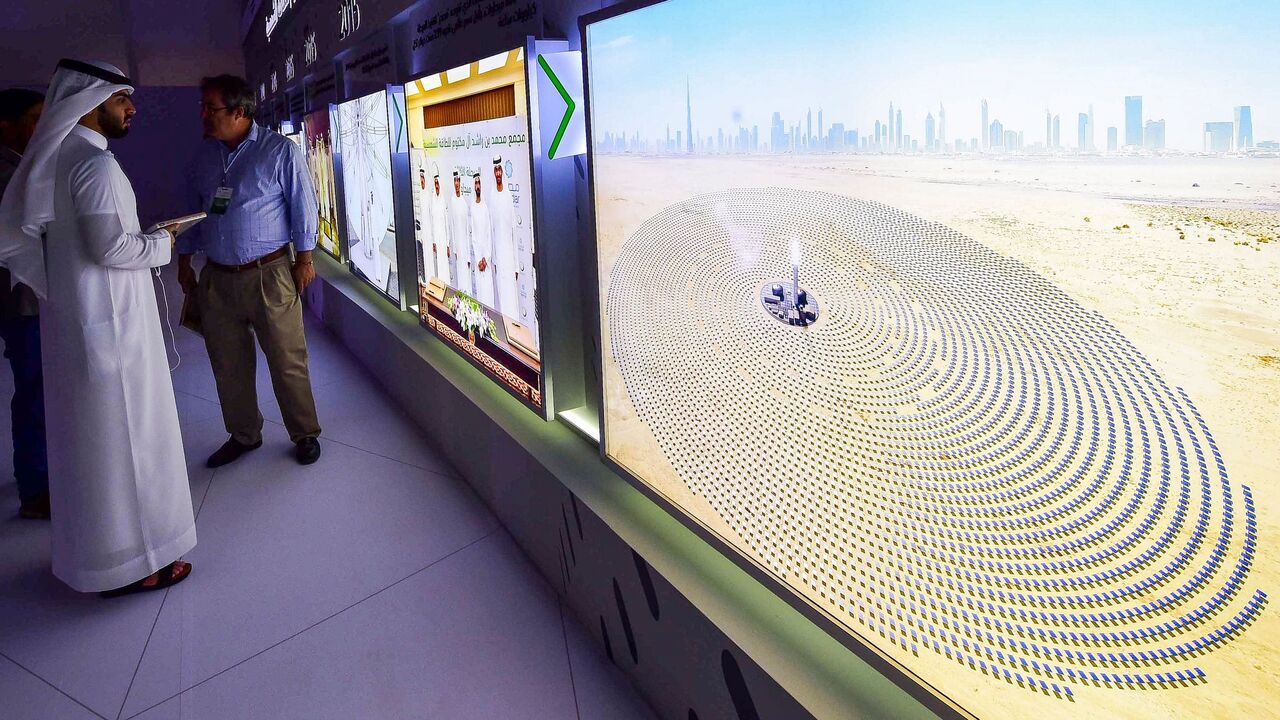 Visitors look at screens displaying images of the Mohammed bin Rashid Al-Maktoum Solar Park on March 20, 2017.