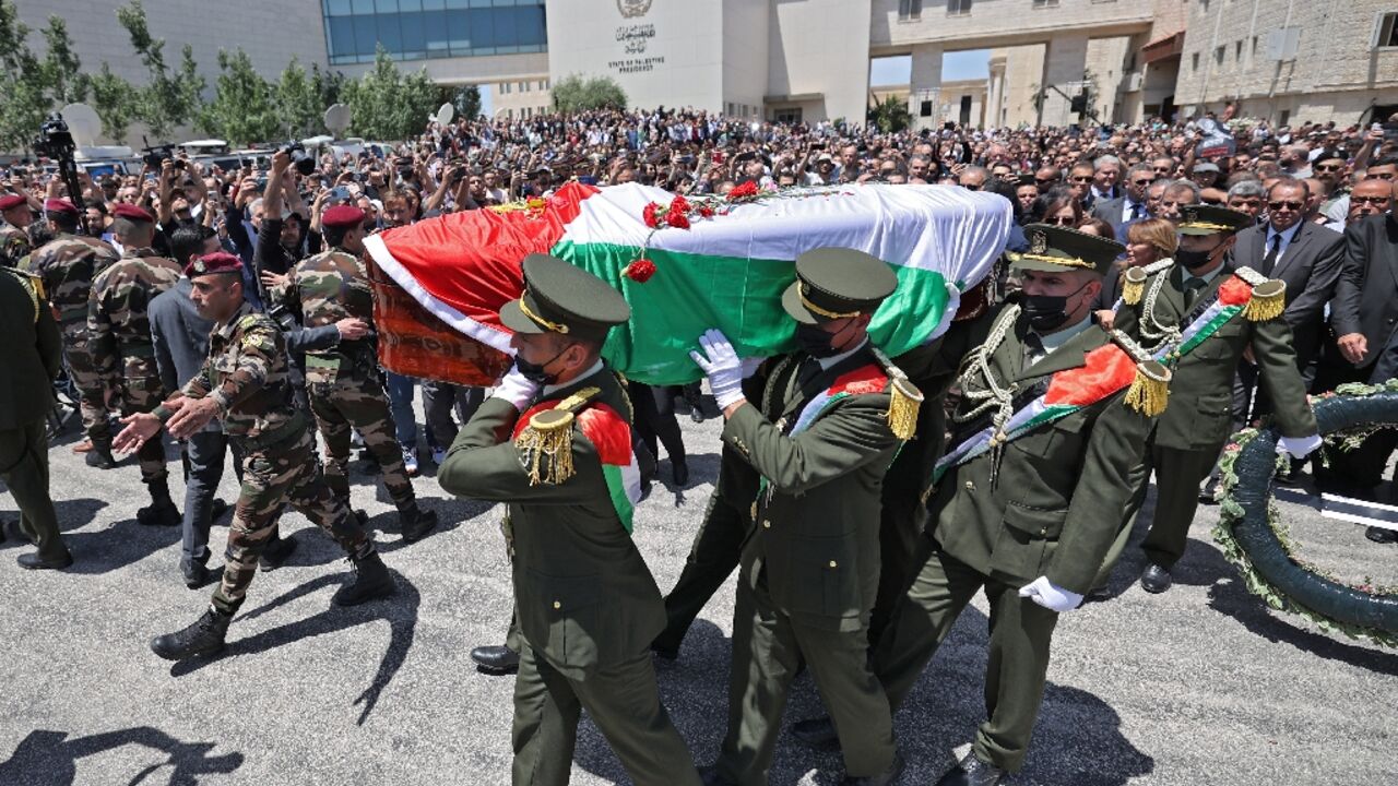 Palestinian honour guards carry the coffin of veteran Al Jazeera journalist Shireen Abu Akleh at the presidential headquarters in the West Bank city of Ramallah