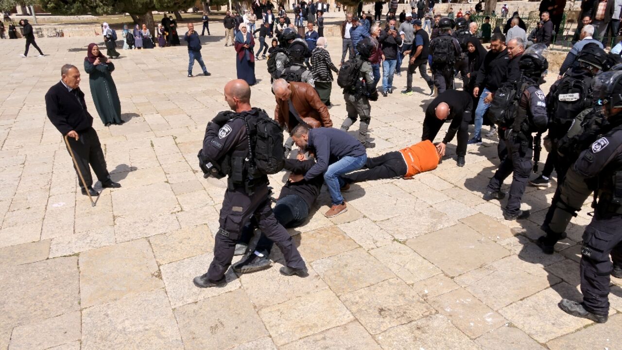 Two people lie on the ground during clashes between Israeli security forces and Palestinians at the Al-Aqsa mosque compound
