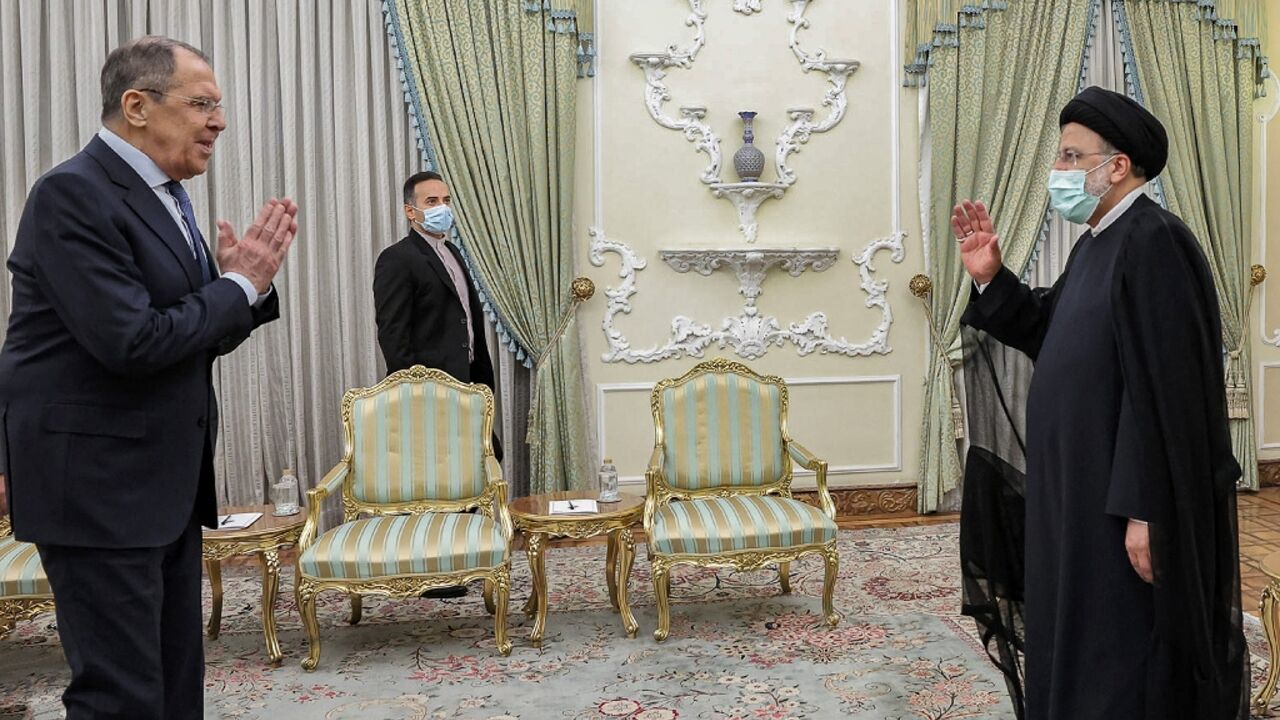 This handout picture shows Russian Foreign Minister Sergei Lavrov meeting Iranian President Ebrahim Raisi during a visit to Tehran in which the two countries will discuss boosting trade and energy cooperation as they grapple with Western sanctions