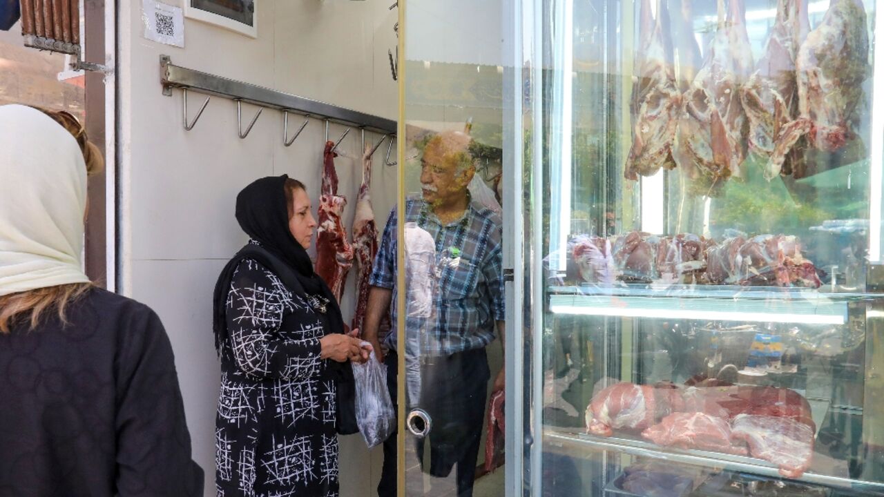 A woman shops at a butcher's in Tehran. Iran has been wrestling with rampant price growth for years, exceeding 30 percent annually every year since 2018, according to the International Monetary Fund