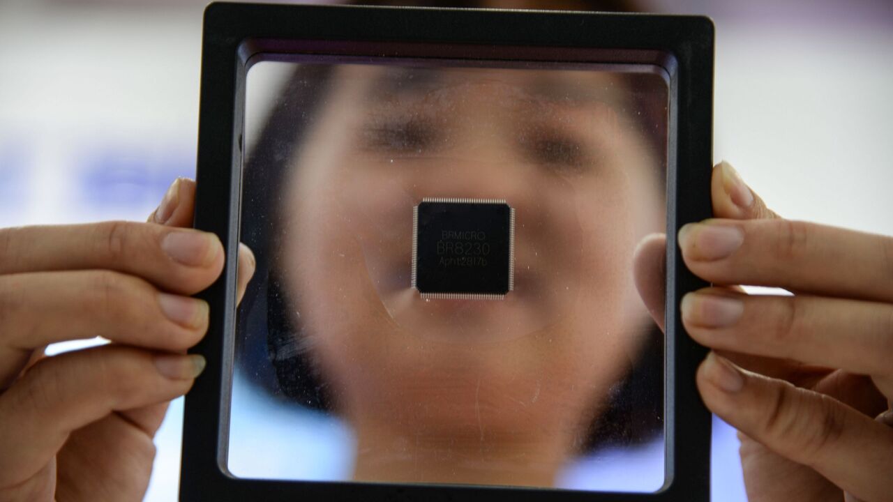 This photo taken on May 11, 2019, shows a Chinese employee holding a self-developed chip at an industrial park in Jinan in China's eastern Shandong province.