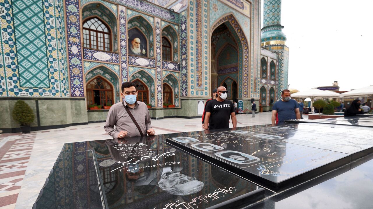 People pay their respects by the grave of Mohsen Fakhrizadeh, an Iranian scientist linked to the country's nuclear program who was killed months before.
