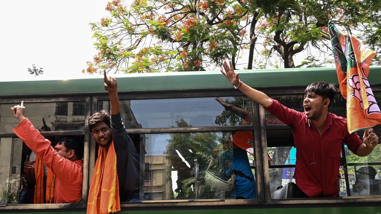 Bharatiya Janata Party (BJP) activists shout slogans from a police vehicle after being detained during a protest against West Bengal's state government over alleged irregularities in the School Service Commission (SSC) recruitment process, in Kolkata on May 20, 2022. 