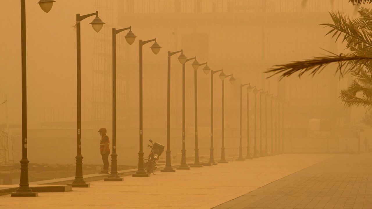 A man stands on the bank of the Shatt al-Arab waterway, formed at the confluence of the Euphrates and Tigris rivers, in Iraq's southern city of Basra on May 23, 2022, during a sandstorm sweeping the country. 