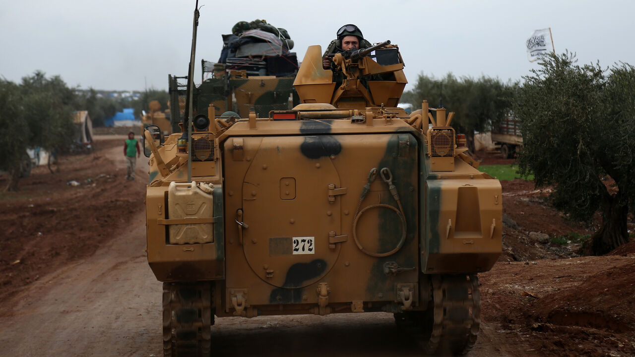 A Turkish soldier mans a turret on an infantry fighting vehicle driving near the village of Yazi Bagh.