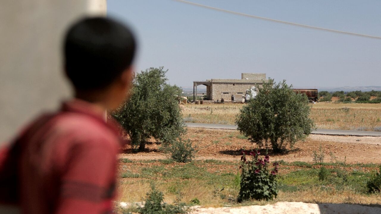 A boy looks at a building where US coalition forces conducted an overnight airborne operation to capture an Islamic State group bombmaker, in the village of Hmeirah in the north of Syria's Aleppo province on June 16, 2022