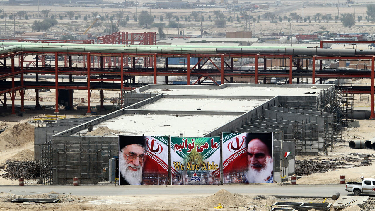 A huge banner bearing portraits of Iran's supreme leader Ayatollah Ali Khamenei (L) and his predecessor, the founder of the Islamic republic, Ayatollah Ruhollah Khomeini (R), is seen on a building being constructed at phase 15 and 16 of South Pars gas field development in the southern Iranian port town of Asaluyeh on July 19, 2010 as a top official announced that global energy majors are welcome to help develop oil and gas projects in Iran despite new sanctions imposed on the Islamic republic. AFP PHOTO/ATT