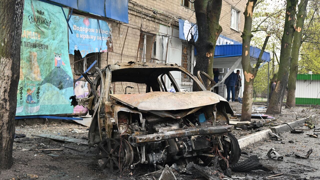 Debris from a destroyed car litter the street at the scene of an explosion near a grocery store, following bombardment at in Ukraine's second city Kharkiv on April 18, 2022. 