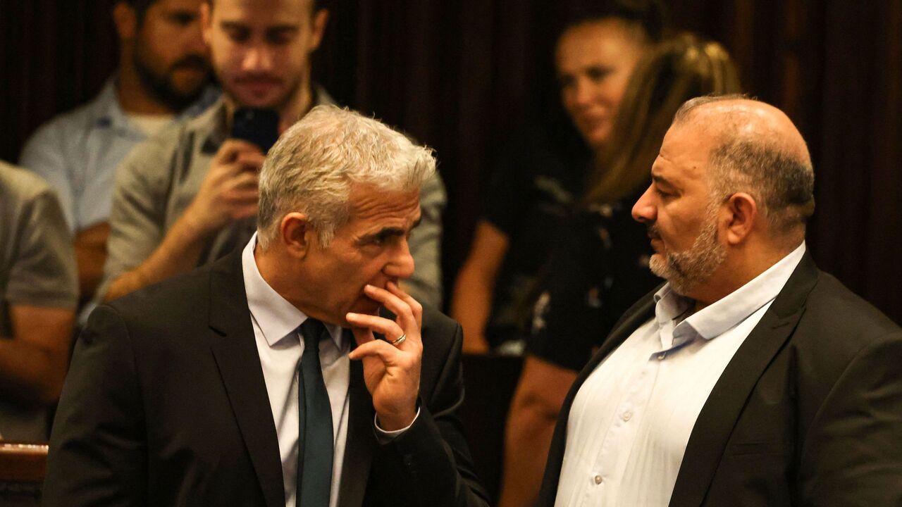 Israeli Minister of Foreign Affairs Yair Lapid (L) speaks to head of Israel's conservative Islamic Raam party Mansour Abbas.