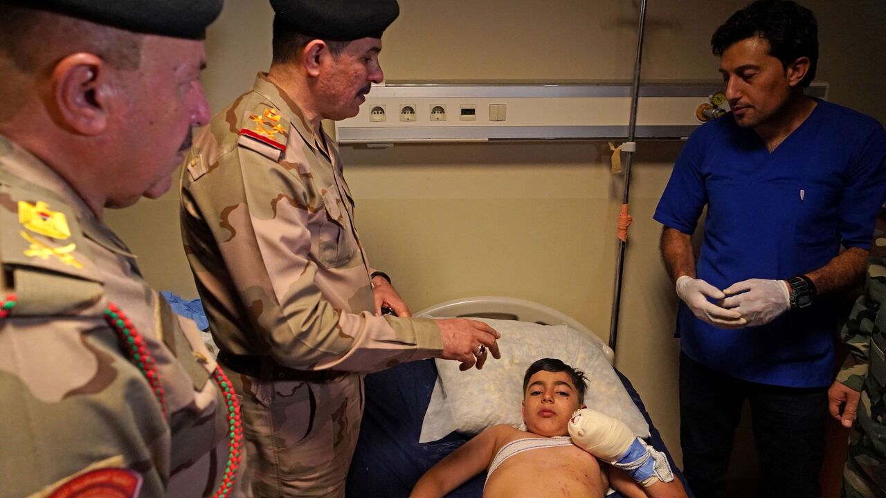 Gen. Mohammed al-Bayati, secretary of the Iraqi prime minister, visits those injured by Turkish shelling at a hospital in the city of Zakho.