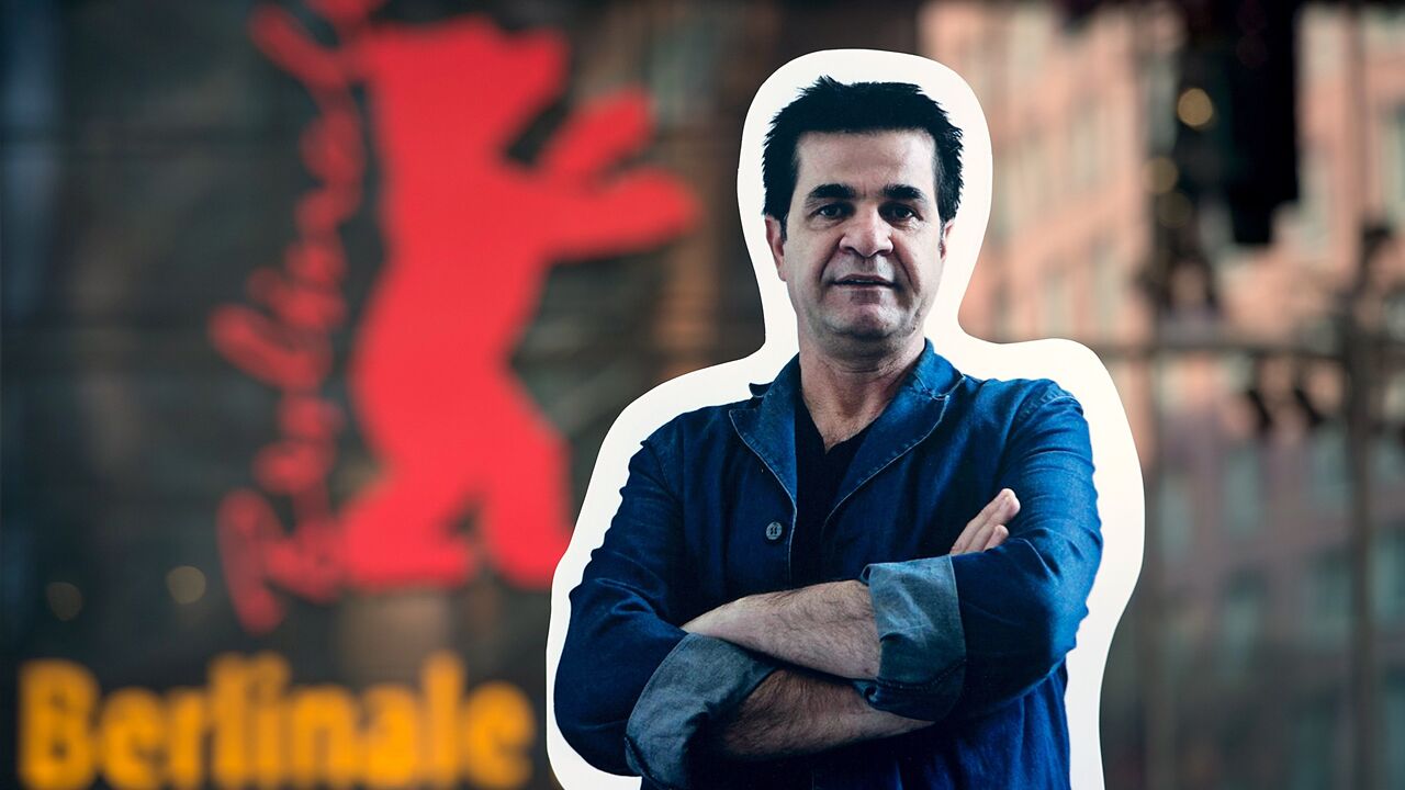 A giant poster featuring Iranian director Jafar Panahi is displayed in front of the Berlinale Festival Palace.