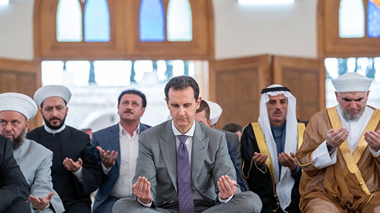 A handout picture released by the official Syrian Arab News Agency (SANA) shows Syria's President Bashar al-Assad (C) attending the Eid al-Adha morning prayer at a mosque in the northern Syrian city of Aleppo on Saturday