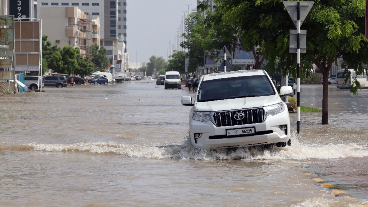A motorist contends with flooding in the port city of Fujairah after unseasonable rains swept through the east of the United Arab Emirates, leaving seven people dead