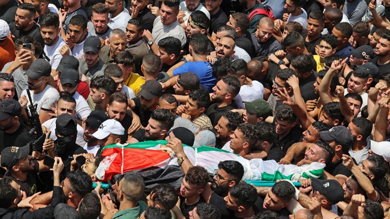 Mourners carry the body of Palestinian commander of the Al-Aqsa Martyrs' Brigade Ibrahim al-Nabulsi, who was killed in an Israeli raid, during a funeral procession in the West Bank city of Nablus