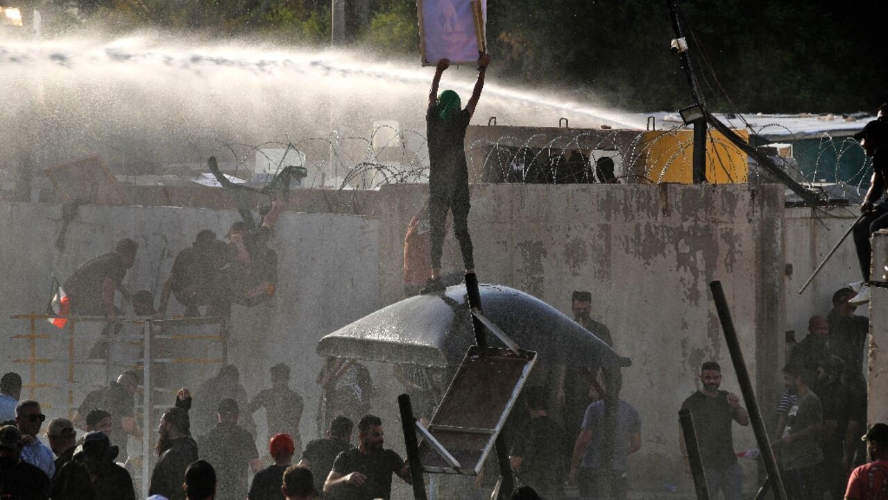Iraqi security forces use a water cannon against supporters of the Coordination Framework to stop them entering the Green Zone on Monday