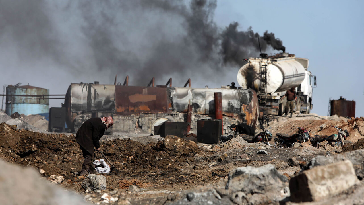 A displaced Syrian man works at a makeshift oil refinery near the village of Tarhin in an area under the control of Turkish-backed factions in the northern countryside of Aleppo, Syria, Feb. 25, 2021.