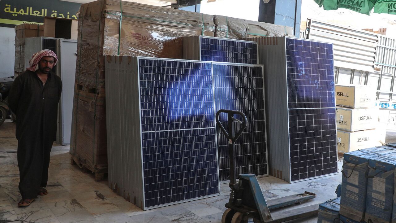 A man stands near solar panels displayed at a shop in the town of Dana, Syria.