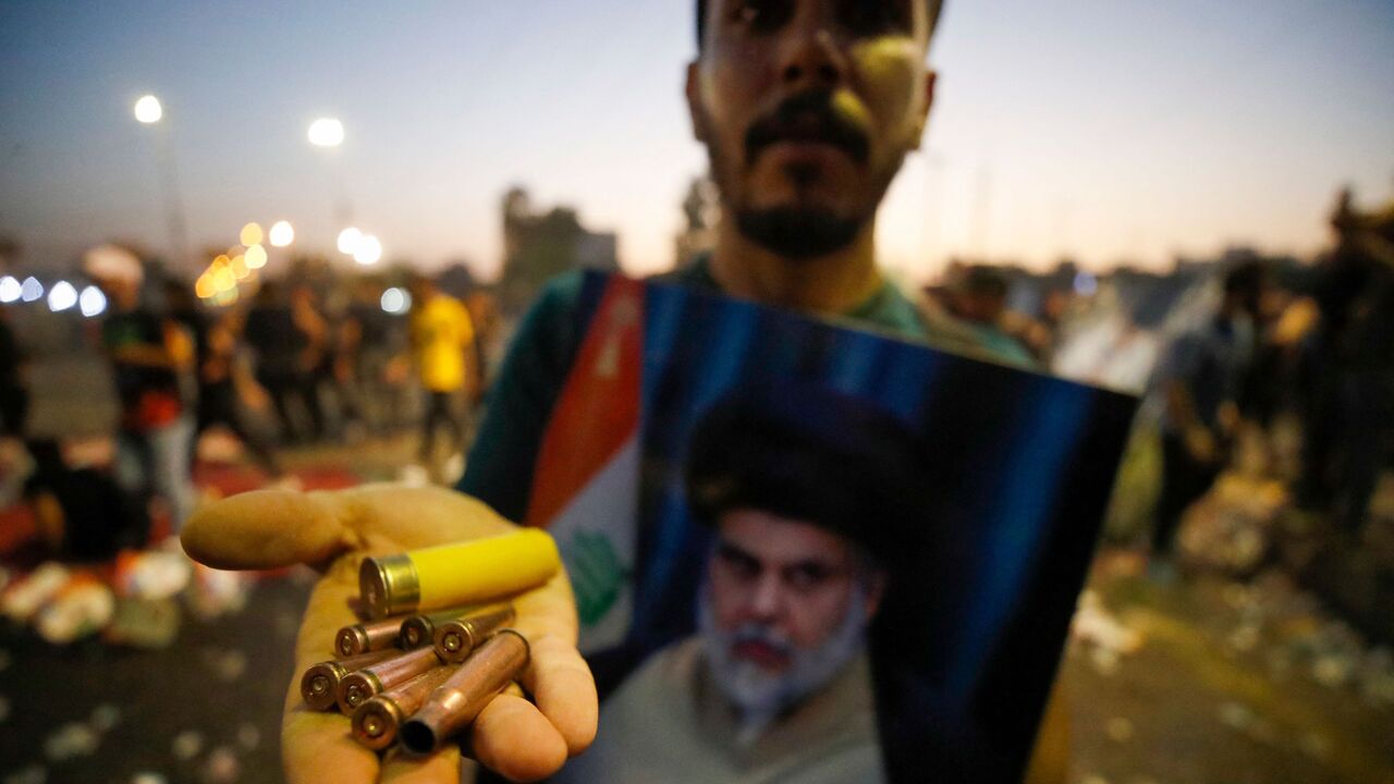 A supporter of Iraqi Shiite cleric Muqtada al-Sadr carries bullet casings and a spent shotgun shell.