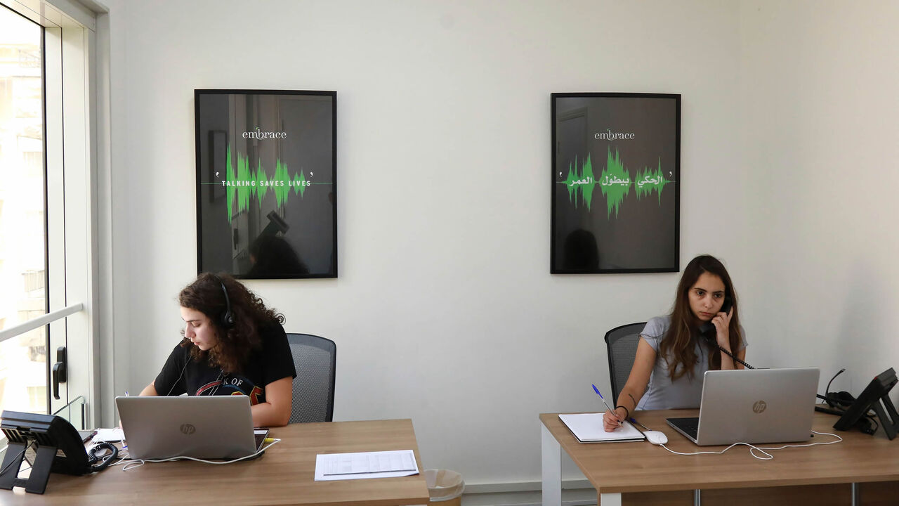 Sally (L) and Serene listen to callers at Embrace, a suicide prevention helpline, Beirut, Lebanon, July 13, 2018.