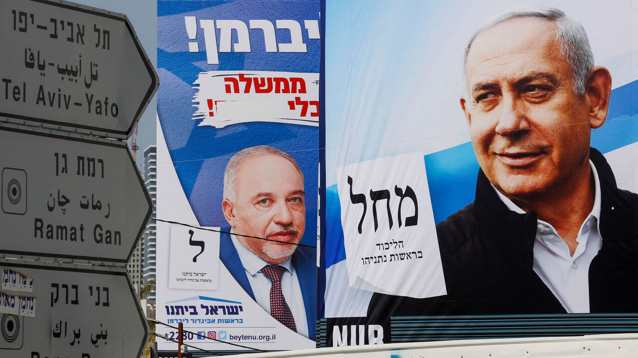 This photo shows election campaign posters of (L to R) Israel's Yisrael Beitenu party bearing a portrait of its leader Avigdor Liberman and the Likud party showing its leader and incumbent Prime Minister Benjamin Netanyahu, Bnei Brak, Israel, March 14, 2021.