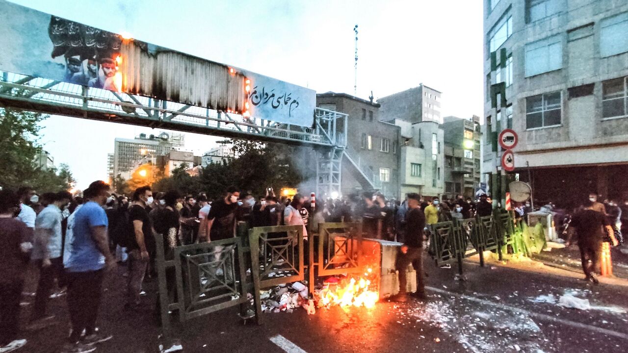 A picture obtained by AFP outside Iran on Sept. 21, 2022, shows Iranian demonstrators burning a rubbish bin in the capital Tehran during a protest for Mahsa Amini, days after she died in police custody. 