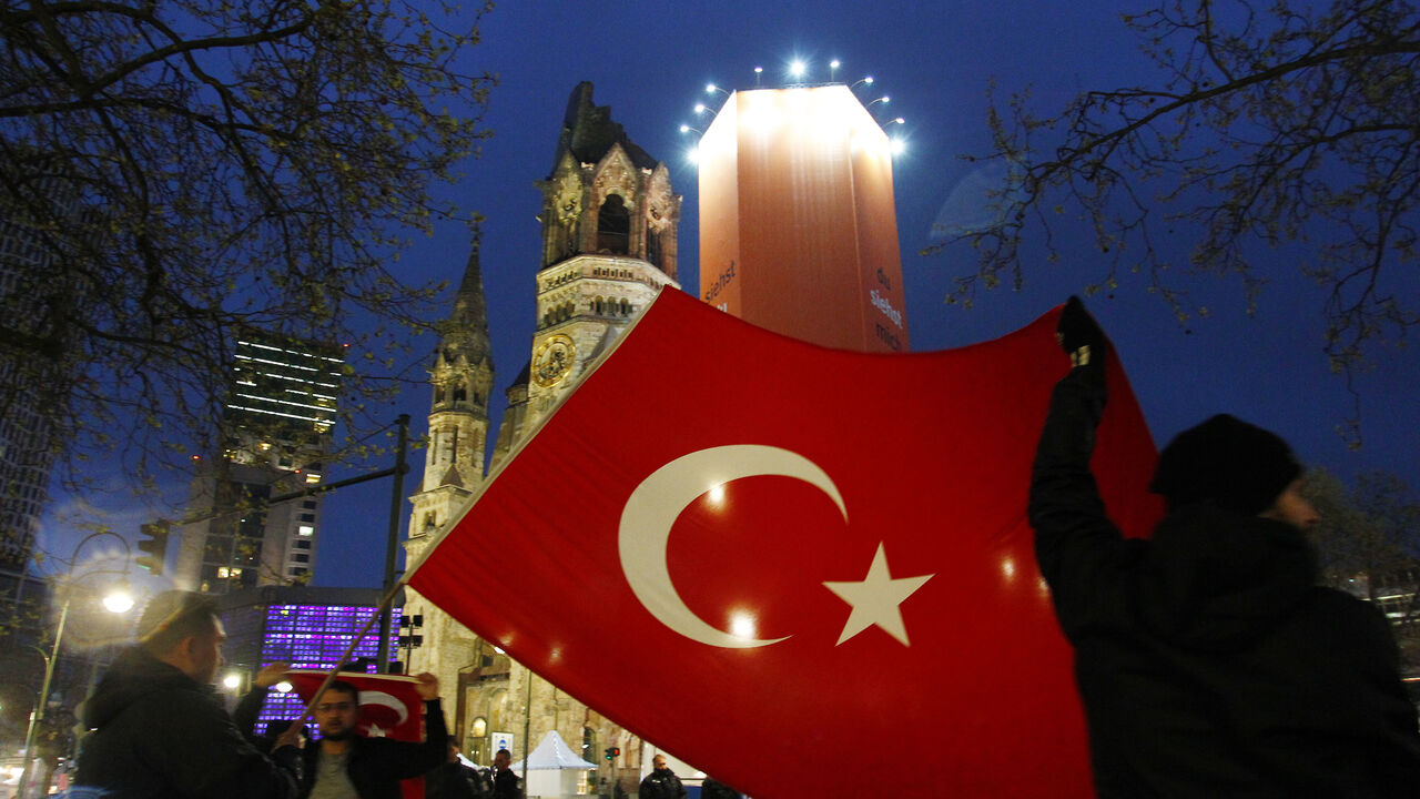 People wave Turkish flags in an immigrant-heavy district.