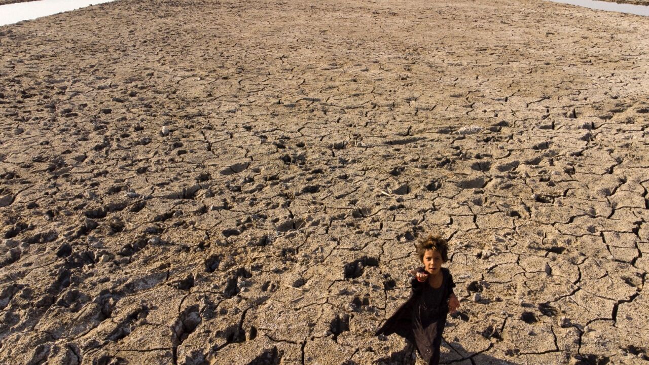 Heatwaves, drought and sandstorms have hit Iraq, one of the countries most threatened by climate change. A child walks though dried marshes in southern Dhi Qar province on August 23, 2022