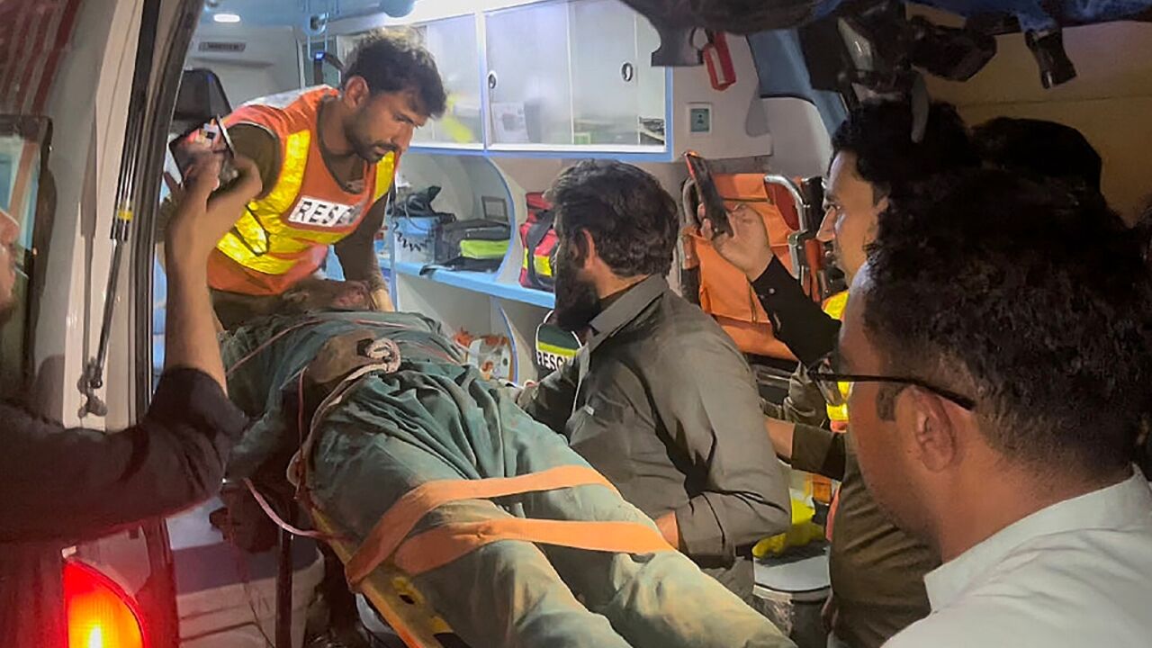 Rescue workers put the body of a victim from the Swat Valley truck blast into an ambulance