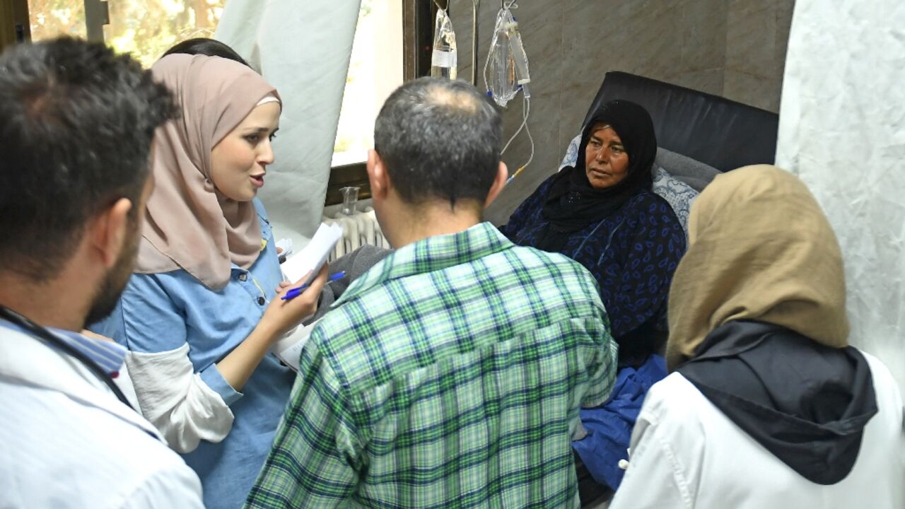 A woman receives treatment for cholera at a hospital in Syria's main northern city of Aleppo