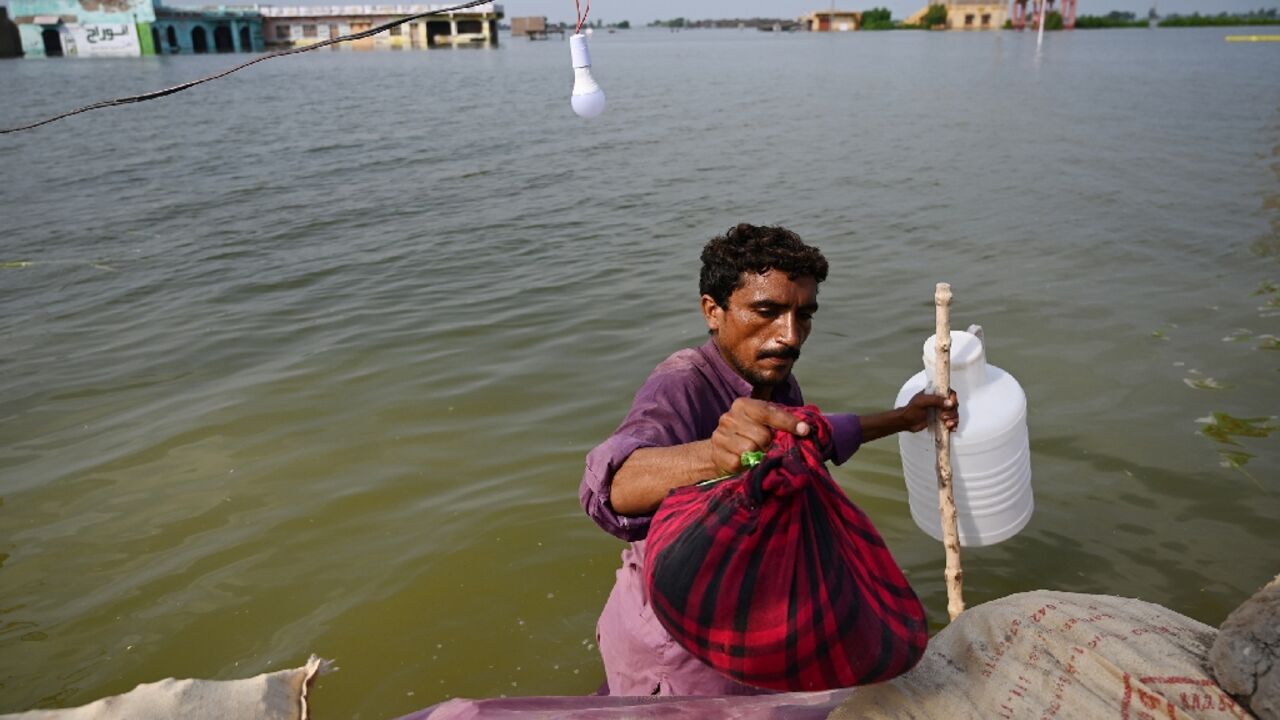 A man prepares to return home after heavy monsoon rains in Pakistan's Sindh province. Developing nations want funding from rich polluters to help them adapt to the impacts of global heating
